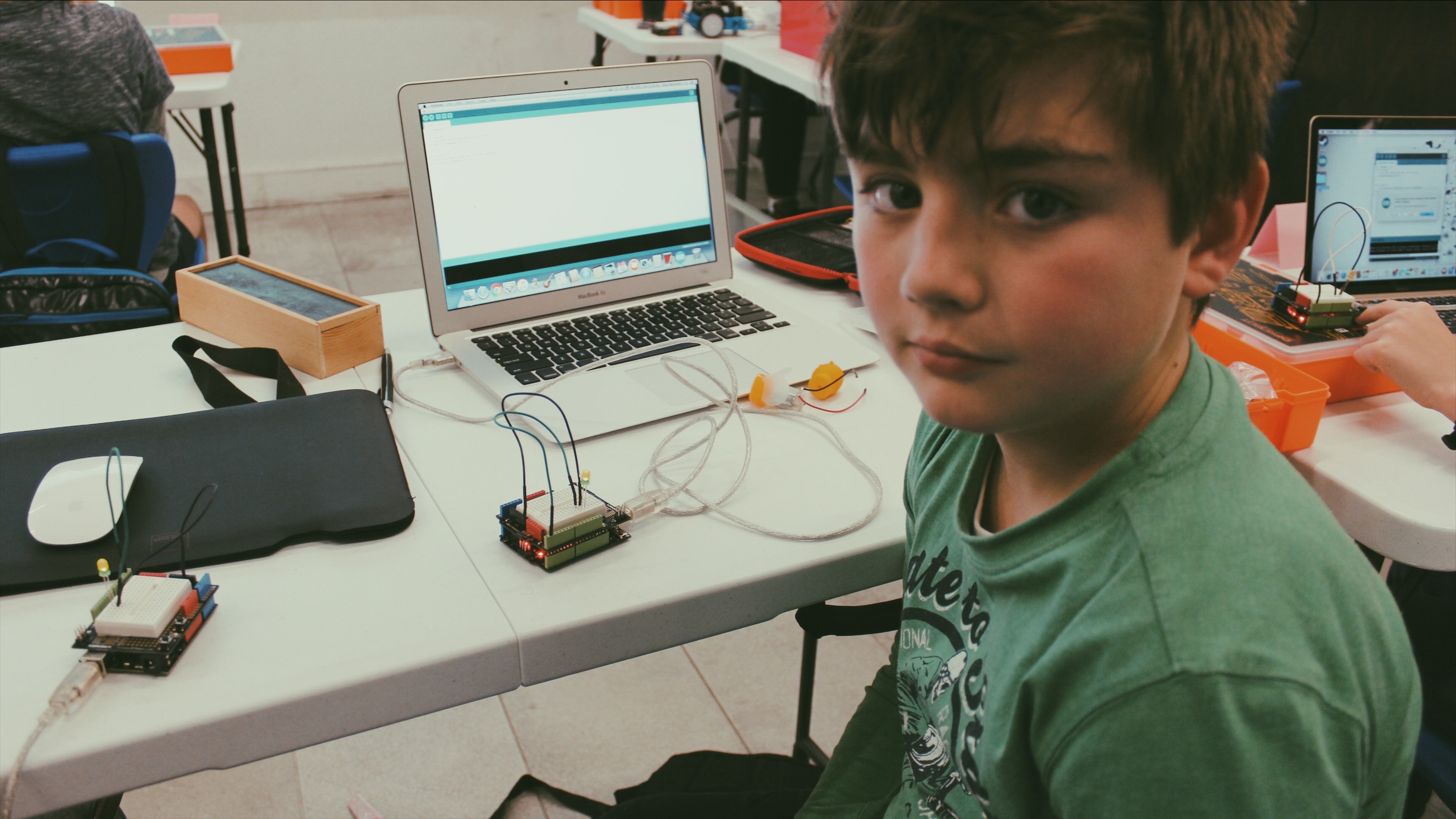 Lemonade Stand Kids Coding: a boy shows off his Arduino